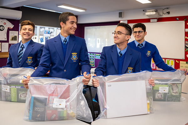 Refugee education packs Catholic Intensive English Centre students Yoneel Marzeena, Danial Mati, Yohan Al-Lalo and Noel Jamil receiving donated education packs.