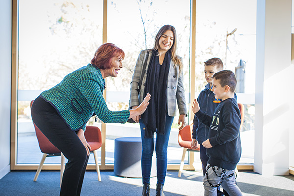 All Hallows Catholic Primary School Five Dock principal Helen Elliott gives a high-five to a boy pupil