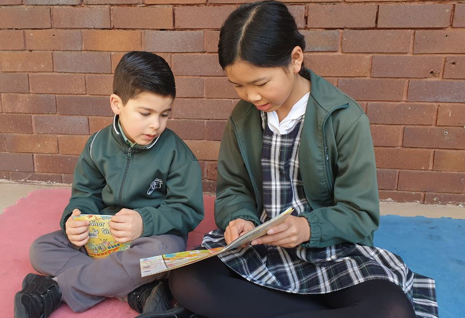 Buddying spells success Our Lady of Fatima Primary School Kingsgrove students read a book together