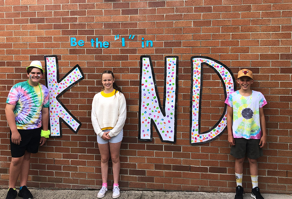 Don’t Worry, Be You St John Bosco Catholic Primary School Engadine students standing in front of a 'Be the I in Kind' mural