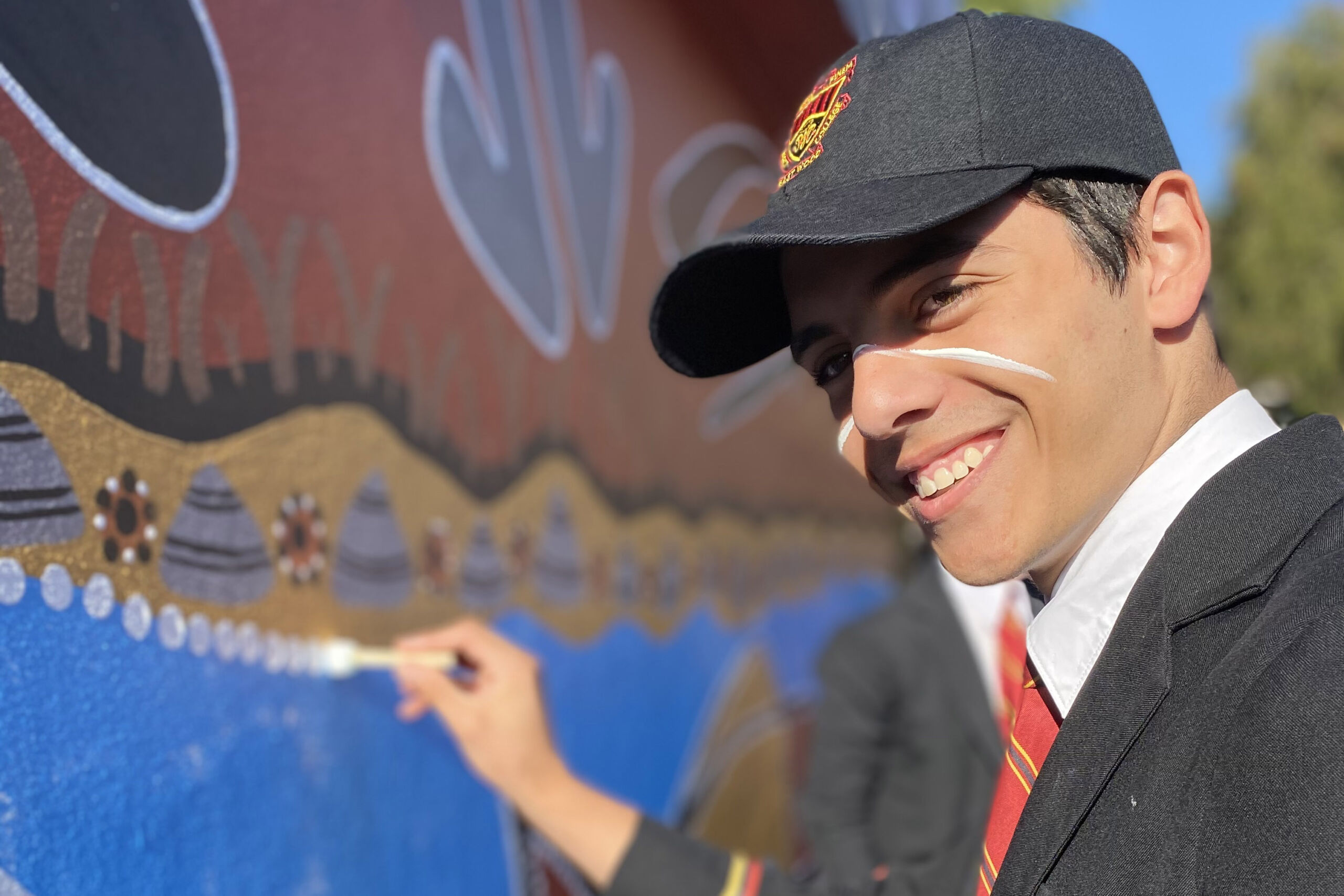 Reconciliation Week Marist College Eastwood male student helps create an Indigenous mural
