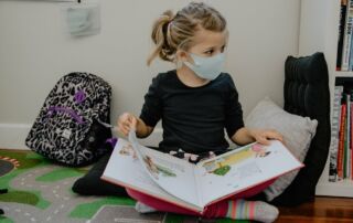 Student reading a book wearing a COVID-19 mask