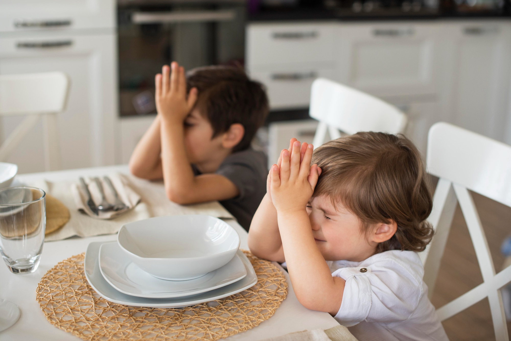 Children pray at the dinner table. Photo created by freepik