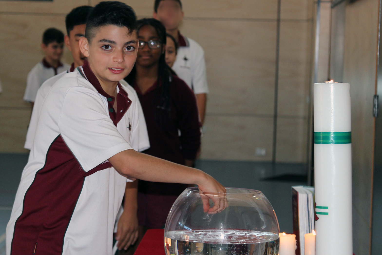 Student with holy water at mass.