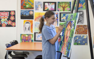 A Sydney Catholic school student paints a portrait in class