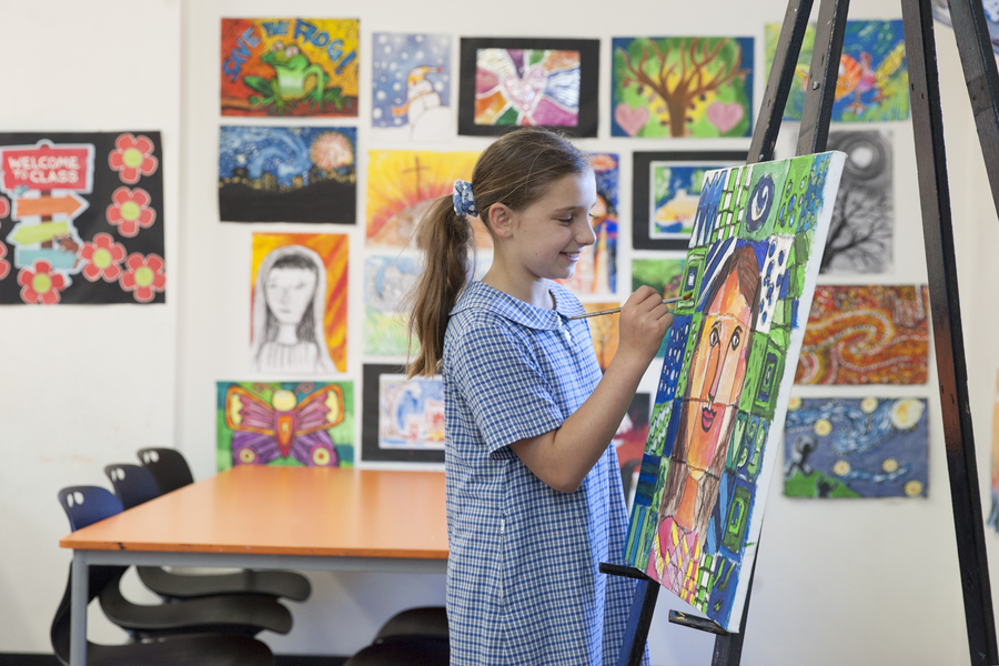 primary school girl painting A Sydney Catholic school student paints a portrait in class