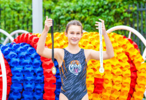 Domremy Catholic College water polo goalie, Emily Broadbent with her sports medals