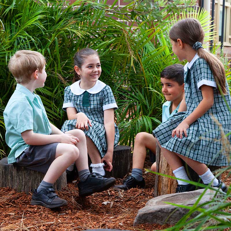 4 students sitting in a garden