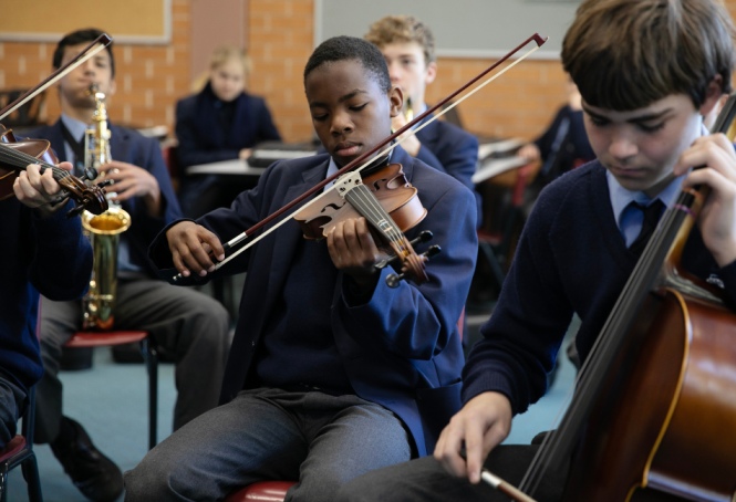 SCS students practice on the viola and violin