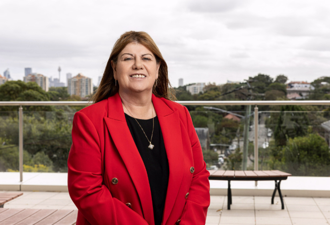 Photo of OLSH Principal Gilda Pussich with Sydney city skyline in the background.