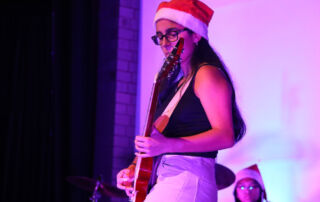 Student plays guitar on stage at the Sydney Catholic Schools Eisteddfod.