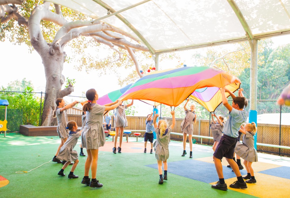 International Day of Play Primary school children gather around a parachute for play.