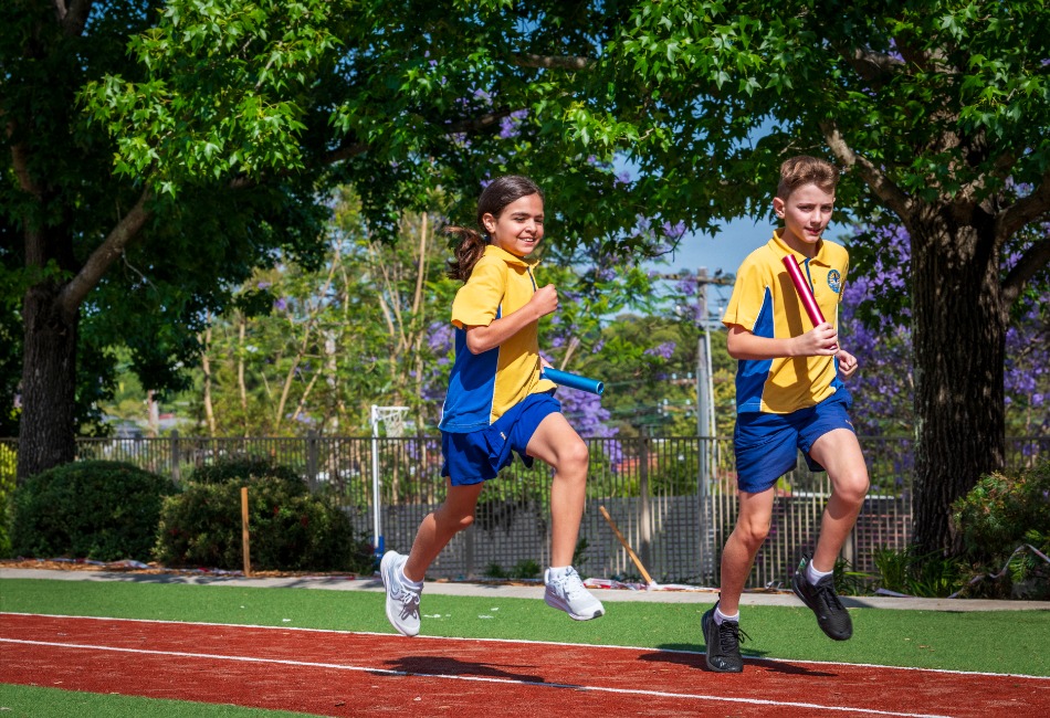 Sport has many benefits for students. Students run a relay on a school athletics track.