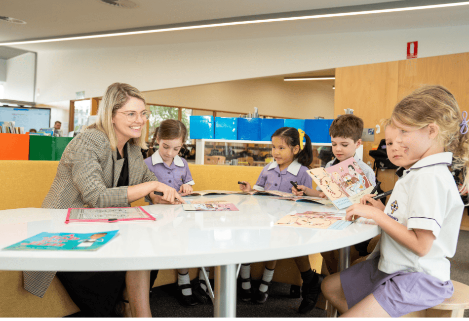 A teacher speaking to primary school students with books smiling in a very modern classroom facility A photo of a teacher speaking to primary school students with books smiling in a very modern classroom facility