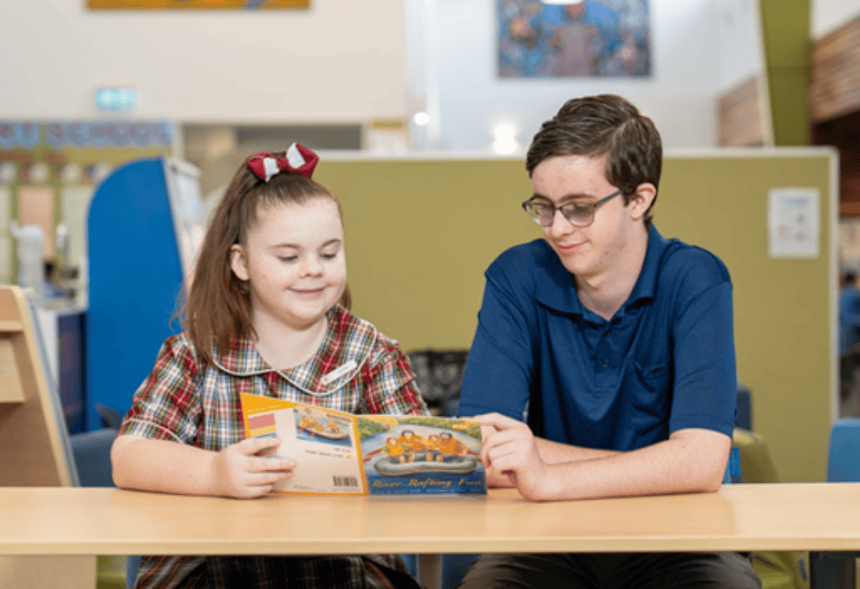 A photo of a School-Based Education Support (SBES) Trainee working with a happy student A photo of a School-Based Education Support (SBES) Trainee working with a happy student