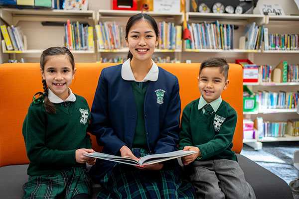 libraries Three students reading a book in a library
