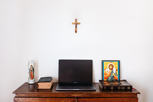 A black laptop, Bibles and religious iconography