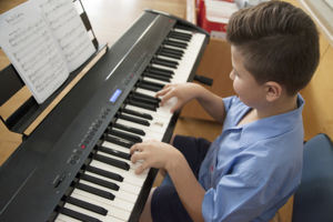 A primary school student plays the piano