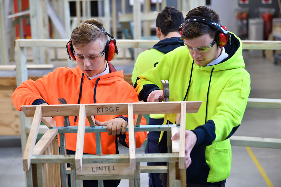 Southern Cross Catholic College Burwood students using hammers on a wooden structure