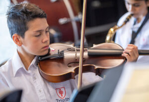 Trinity College Auburn Regents Park male student plays violin as part of Amadeus Music Education Program
