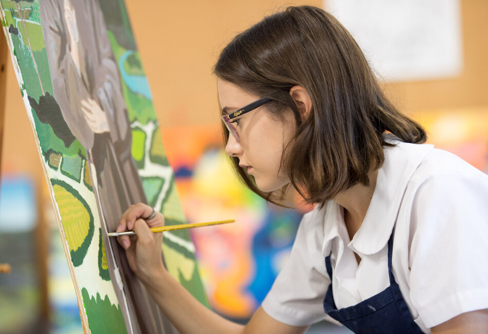 A secondary student is painting
