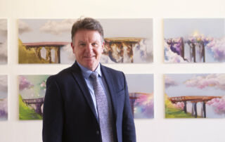 Sydney Catholic Schools' Executive Director, Tony Farley, stands in front of a winning Clancy Prize 2022 artwork