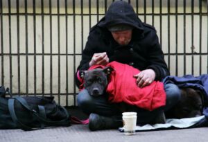 A homeless man with his dog on a London street
