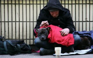 A homeless man with his dog on a London street