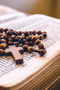 Wooden rosary beads and a Bible