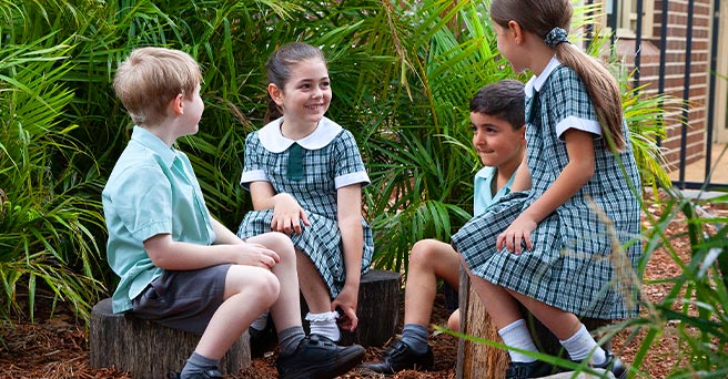 4 students sitting in a garden