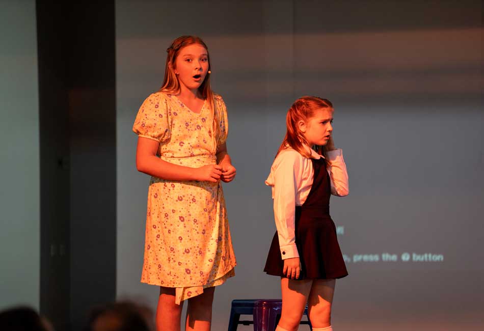 Students performing Matilda Jnr, The Musical on stage.
