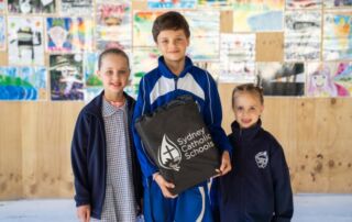 Photo of Volodymyr with his two sisters following a school presentation at Regina Coeli Catholic Primary School Beverly Hills