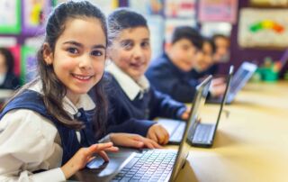 Primary school students work on laptops