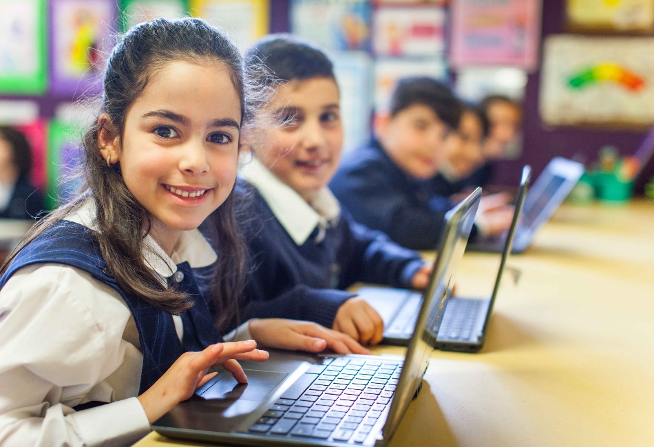 Primary school students work on laptops