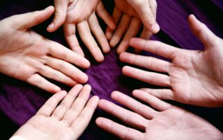 A picture of a group of hands coming together representing The Giving Circle