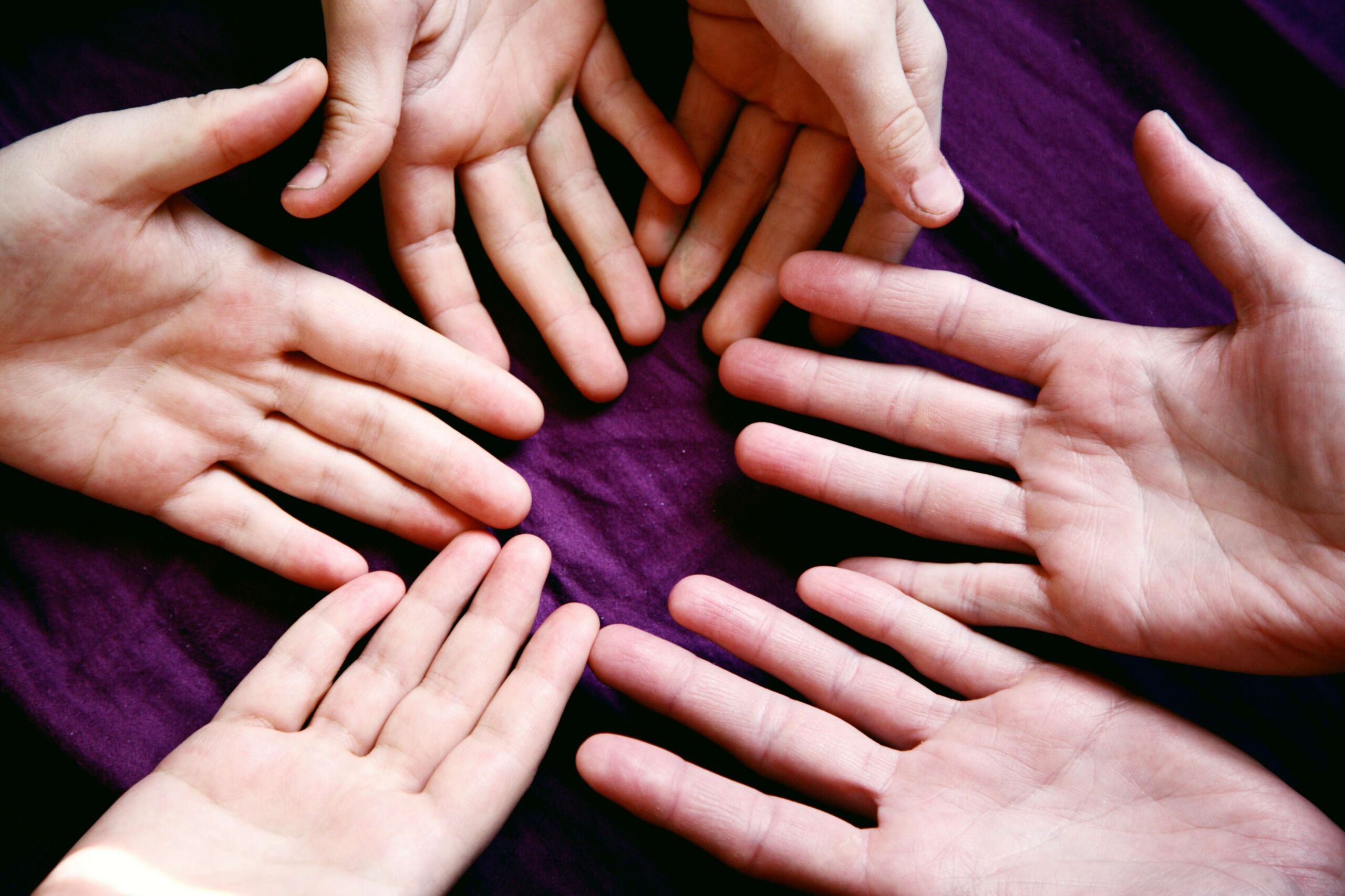 A picture of a group of hands coming together representing The Giving Circle