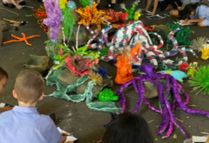 Students construct their ocean-themes sculpture on the playground