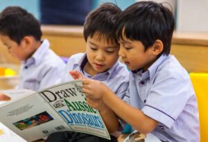 Kindergarten students read a book together.