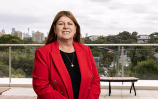 Photo of OLSH Principal Gilda Pussich with Sydney city skyline in the background.