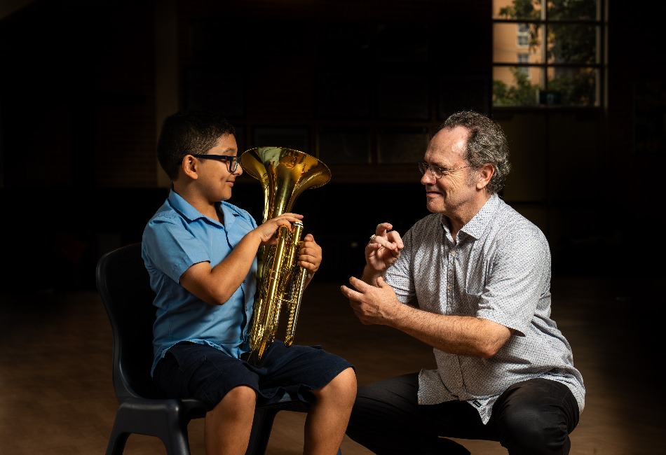 A student learns a brass instrument with an Amadeus Music Education Program tutor.