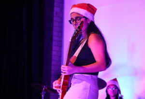 Student plays guitar on stage at the Sydney Catholic Schools Eisteddfod.