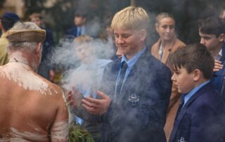 A student from Aquinas Catholic College Menai takes part in a traditional Aboriginal Smoking Ceremony