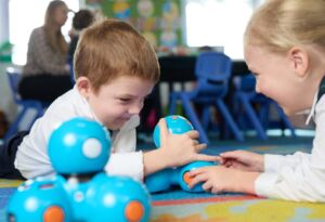 Young students practise digital skills with robots in the classroom.