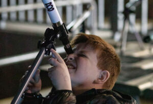 A boy looks through a telescope at Domremy College's Festival of Light.