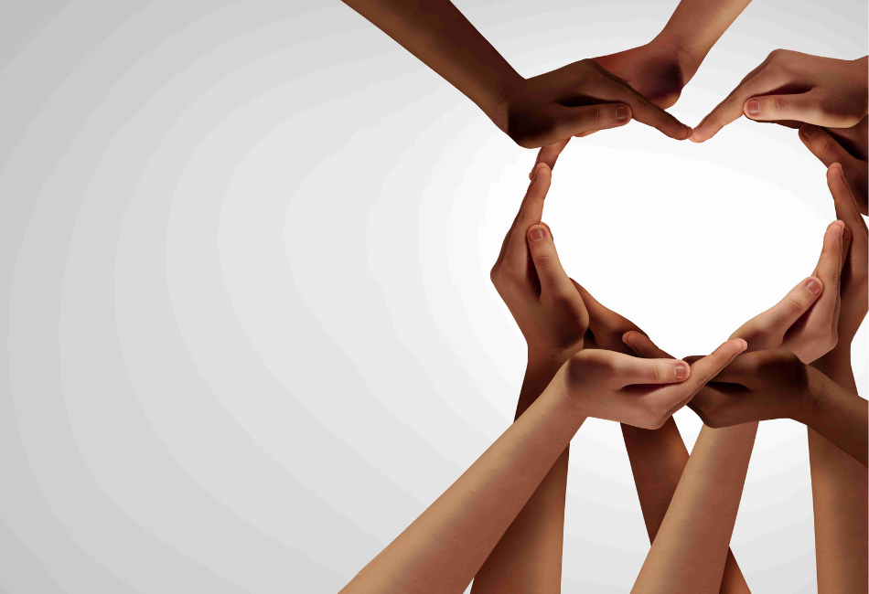 A group of students hands and arms clasp together in support to make the outline of a heart