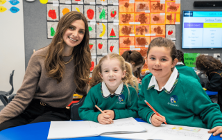 A photo showing a teacher and scholarship recipient with two female students