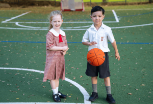 A photo showing two students playing in the school's spacious playground