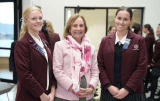 A photo of two students with St Clare's College Waverly Principal Ann Freeman standing in the foyer of the innovative Lumos Centre
