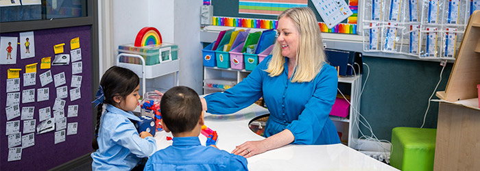 a teacher teaching a boy and girl student