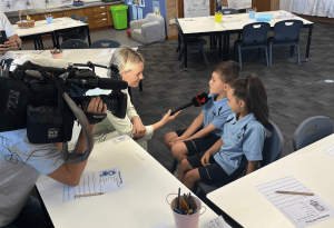 A photo showing two St Kevin's Eastwood being interviewed by a 7News reporter and cameraman